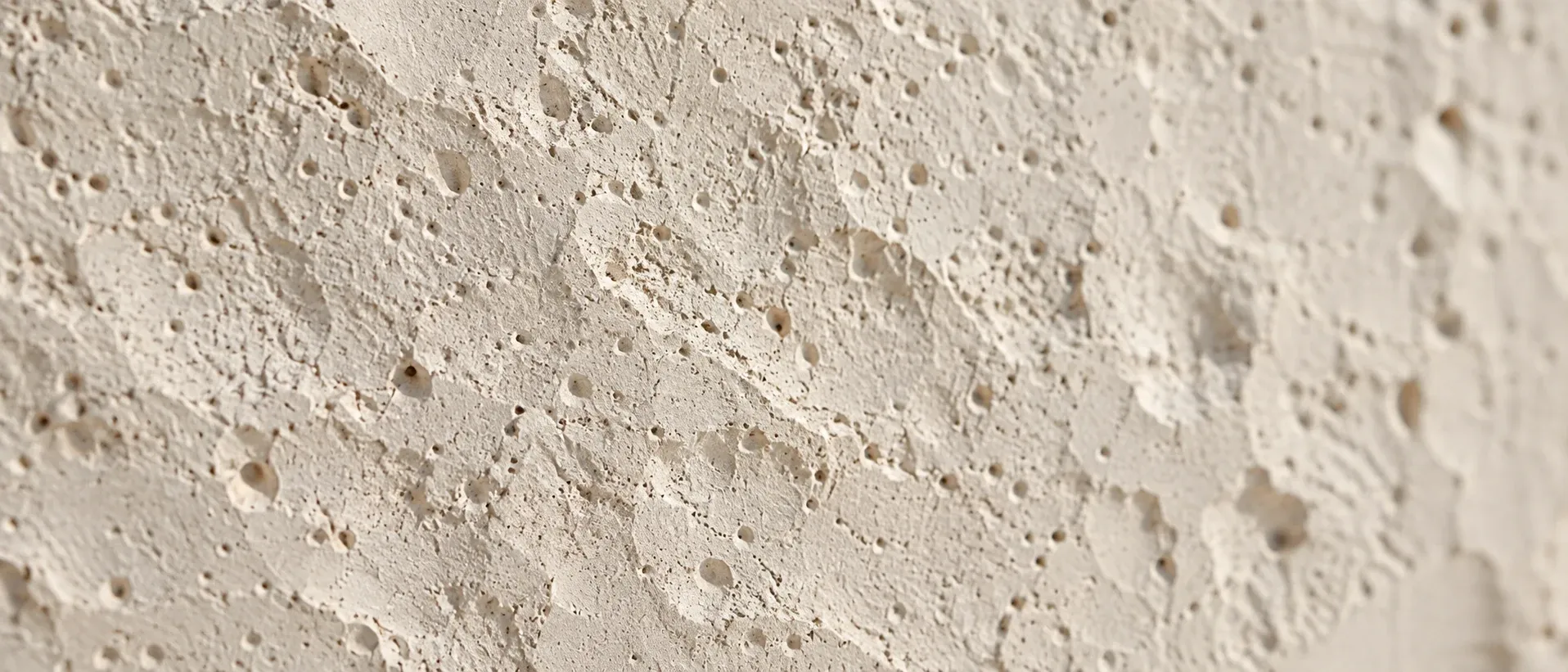 Dimpled texture across a pale plaster surface
