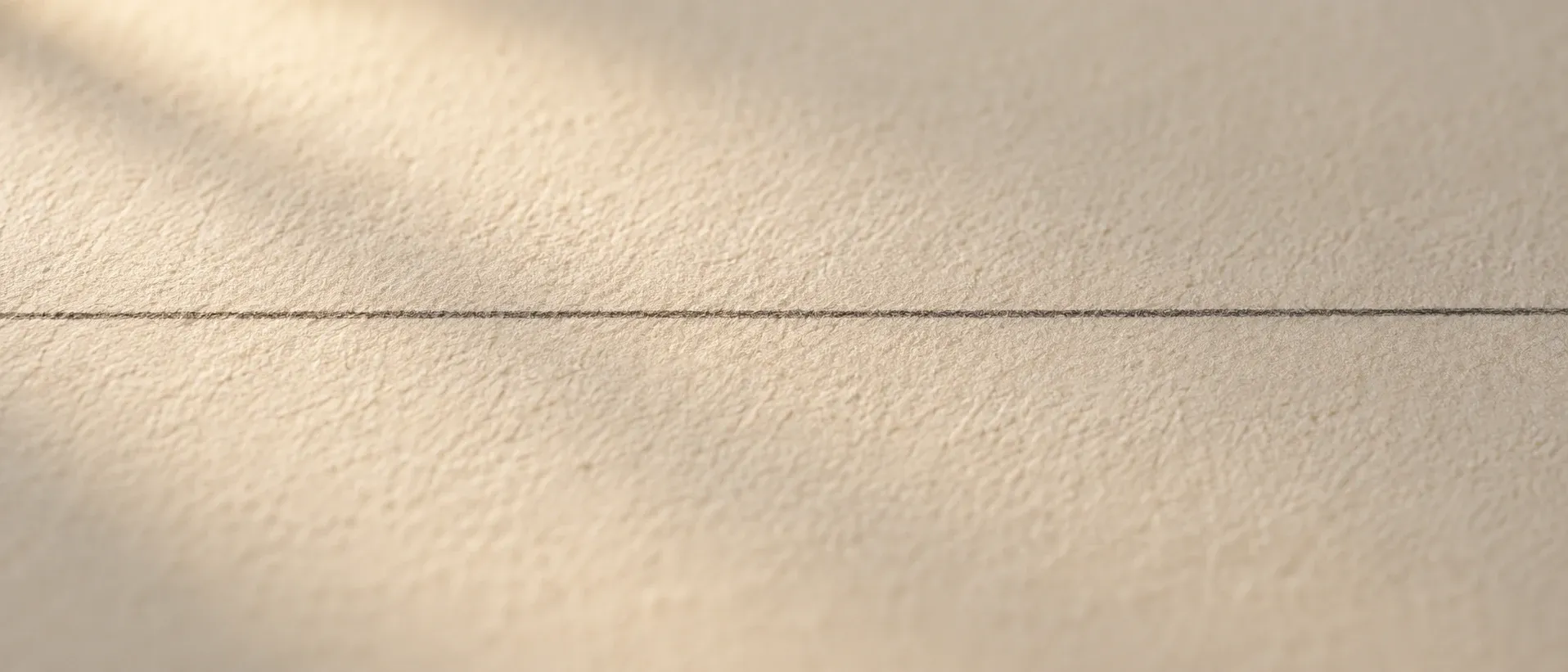 A straight line drawn across textured paper