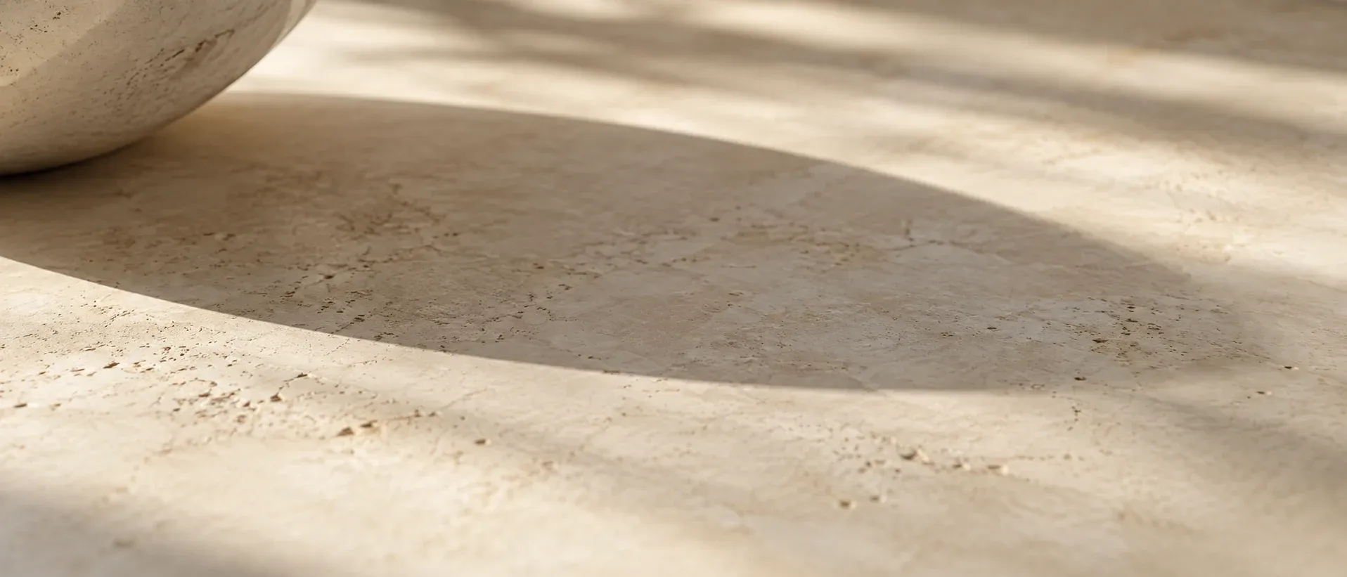 A curved shadow falling across a pale stone surface