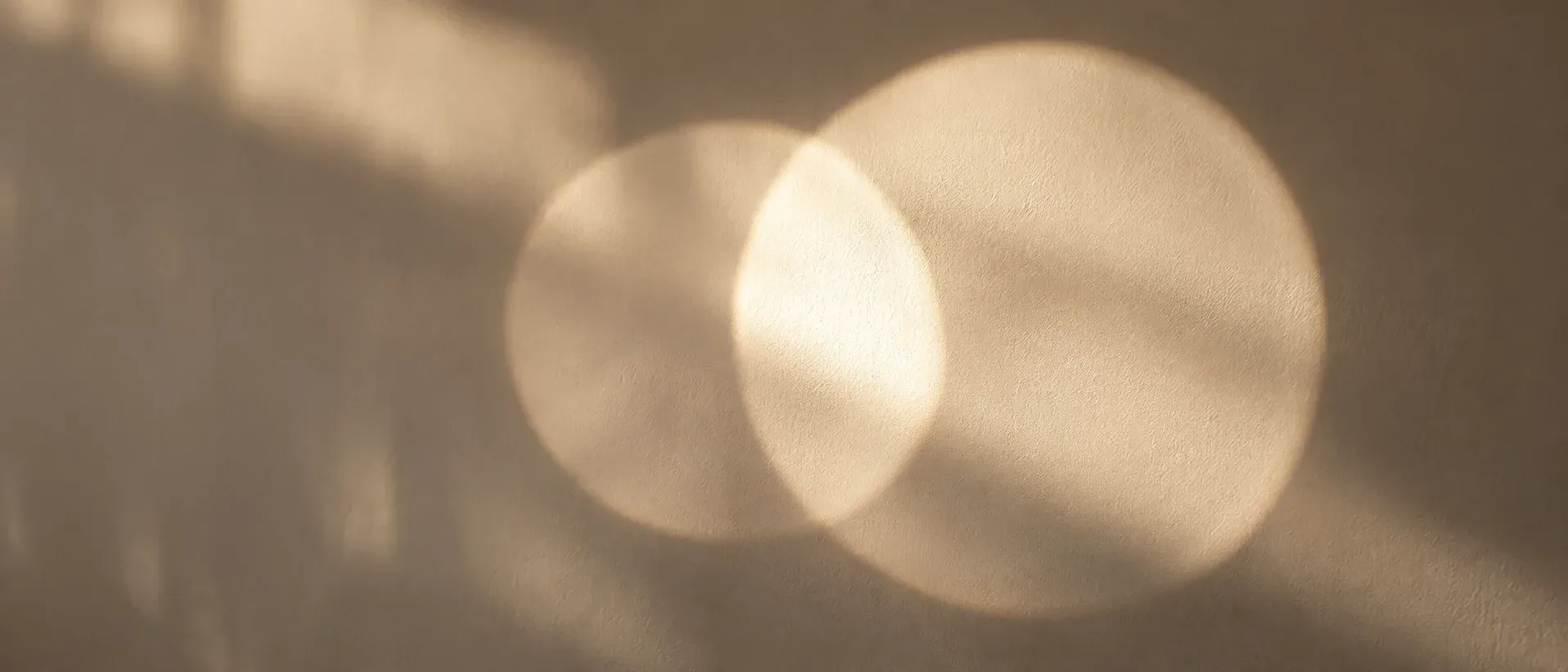Two overlapping circles of light on a plain wall